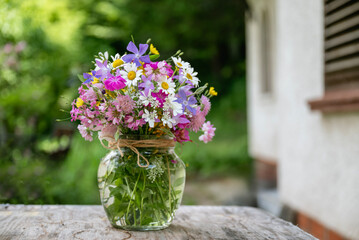Glass vase with beautiful bouquet of summer wild flowers