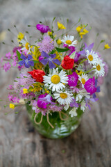Glass vase with beautiful bouquet of summer wild flowers