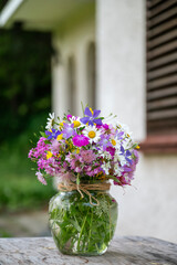 Glass vase with beautiful bouquet of summer wild flowers