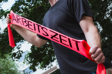 Mann stretched die Arbeitszeit mit einem Fitness Band 