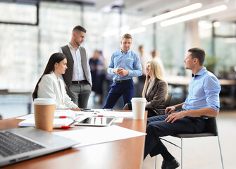 Team young professionals having casual discussion in office. Executives having friendly discussion during break.