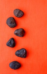 Dark Stones Arranged on Vibrant Orange Background