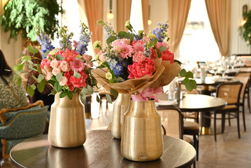 Finished flower bouquets created during the workshop are displayed in a vase.








