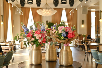 Finished flower bouquets created during the workshop are displayed in a vase.









