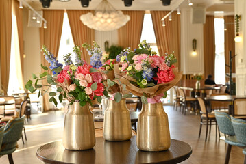 Finished flower bouquets created during the workshop are displayed in a vase.








