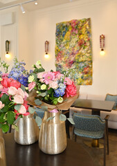 Finished flower bouquets created during the workshop are displayed in a vase.








