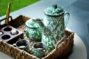 A tea set arranged on a woven wicker tray.