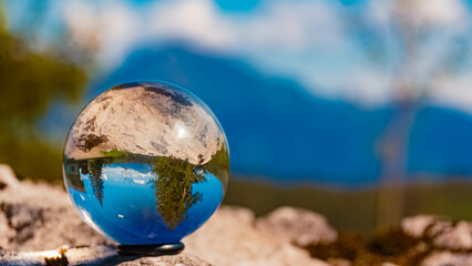 Crystal ball alpine spring landscape shot with Mount Kitzbueheler Horn in the background at Wochenbrunner Alm, Ellmau, Kufstein, Tyrol, Austria