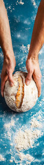 Close-up of a professional baker's hands meticulously preparing artisanal sourdough bread vertical banner - wide skyscraper - blue background
