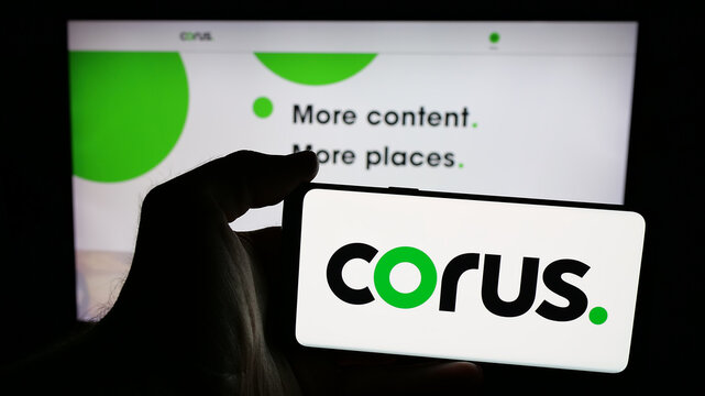 Stuttgart, Germany - 06-09-2025: Person holding mobile phone with logo of media company Corus Entertainment Inc. on screen in front of web page. Focus on phone display.
