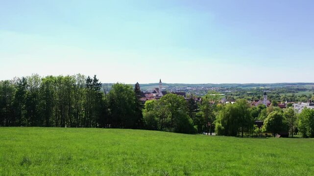 Luftaufnahme von Donauw&ouml;rth mit roten D&auml;chern, historischen Geb&auml;uden und einem markanten Turm, eingebettet in eine gr&uuml;ne Landschaft. Die Stadt bietet eine charmante Kulisse. 