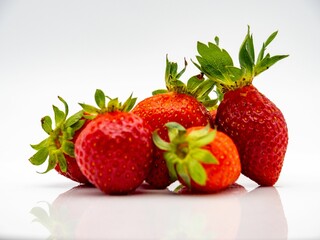 Fresh strawberries on a reflective surface.