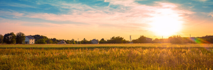 View of a wheat field with beautiful sunset sky. Panorama. Horizontal banner
