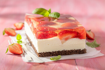 Homemade and sweet strawberry cheesecake with transparent jelly and cream.