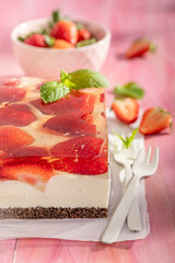 Homemade and sweet strawberry cheesecake with berry jelly and cream.