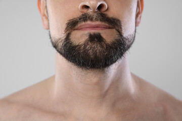 Man with beard on grey background, closeup