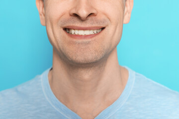 Smiling man after shaving on light blue background, closeup