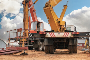 Heavy machinery and construction vehicles working at a busy construction site under a clear blue sky