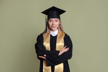 Happy student after graduation on green background