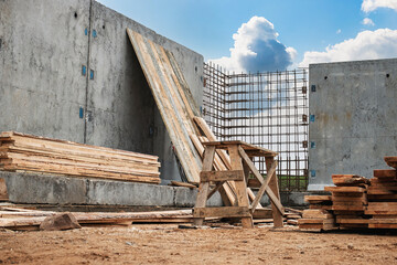 Construction site with wooden materials and steel reinforcement under clear blue sky