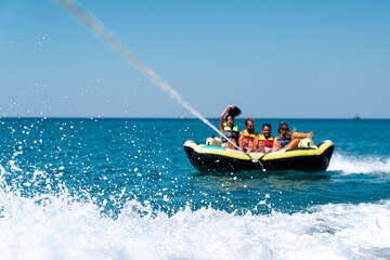 A group of friend having fun behind a speedboad on the sea