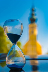 Hourglass landscape shot with a church and reflections on a car roof at Sammarei, Ortenburg, Passau, Bavaria, Germany