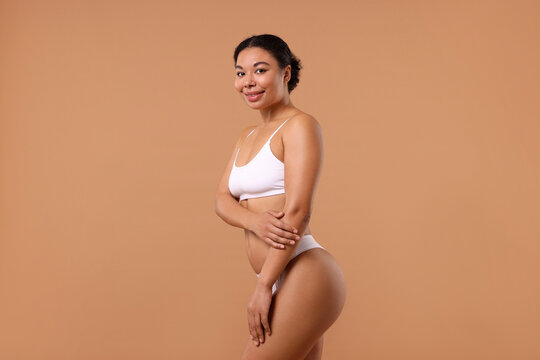 Fototapeta Woman in white underwear with smooth skin after epilation procedure on beige background