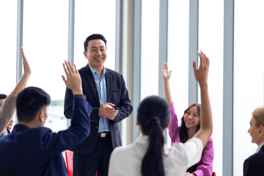 Public speaking training in seminar : Asian business man leader in seminar, speaking on business training with group of diverse people company employees in meeting room