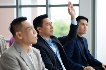 Question and answer audience or crowd : Active participation Asian man raise hands to ask questions attending seminar in conference meeting and training