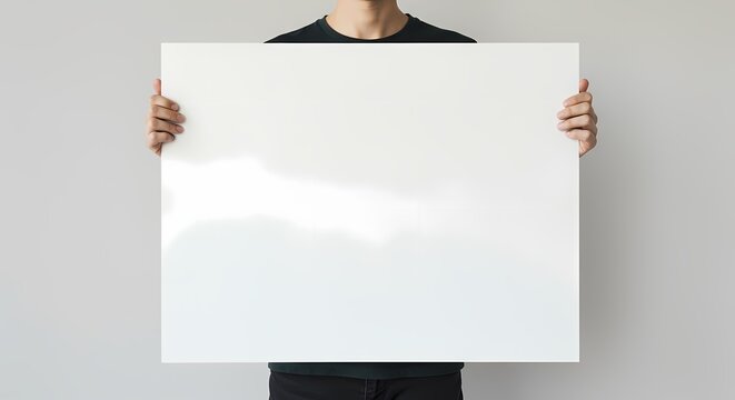 A person holding a blank white poster horizontally, suitable for adding text.