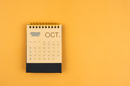 October 2025 calendar from brown craft paper on yellow color background.