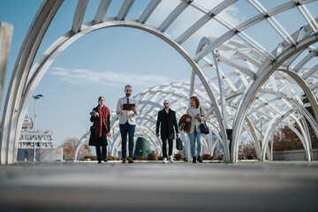 Four business individuals in formal and casual attire walking, engaging with each other under a...
