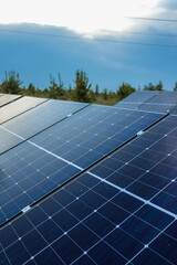 Close-up of solar panels in rural field generating renewable energy from sunlight with blurred...