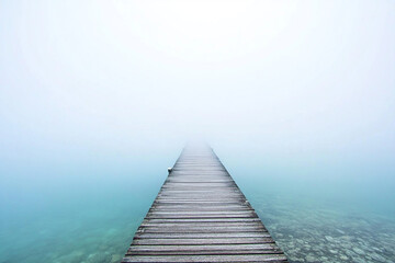 Foggy pier stretches into calm waters shrouded in mist