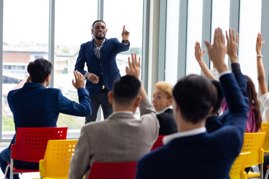 Question and answer audience or crowd : Active participation Asian man raise hands to ask questions attending seminar in conference meeting and training
