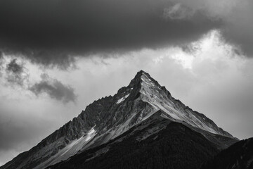 A black and white photo of a snowy mountain landscape with snow-covered peaks and trees
