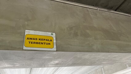 Warning Sign Mind Your Head in Industrial Concrete Structure – Safety Alert