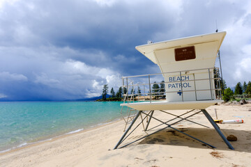 Beach Patrol lifeguard stand on a sandy beach with blue seas and stormy weather