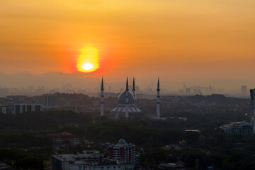 The mosque stands tall against the backdrop of a city
