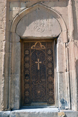 Wooden church door with a cross. Cross on the door of the monastery