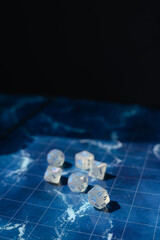 Shimmering RPG dice with blue numbers nestled in the coils of a black dragon figure. A moody fantasy setup perfect for tabletop, DnD, and role-playing game visuals.
