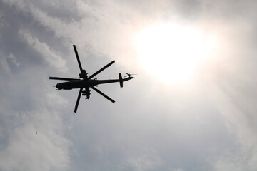 A helicopter will fly into the sky against the background of the sun