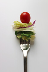 Photo of salad vegetables and tomatoes on a fork