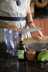 Woman Slicing Fresh Ginger on Wooden Cutting Board
