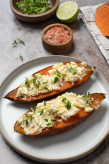 Baked sweet potatoes with ricotta and fresh herbs. Healthy and vegan food