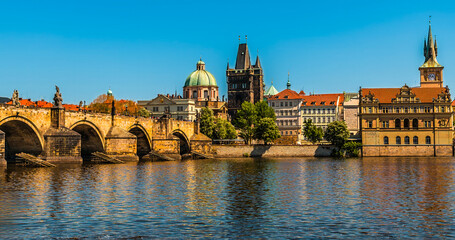 A panorama view of the Charles Bridge and the eastern shore of the Vltava river in Prague in springtime