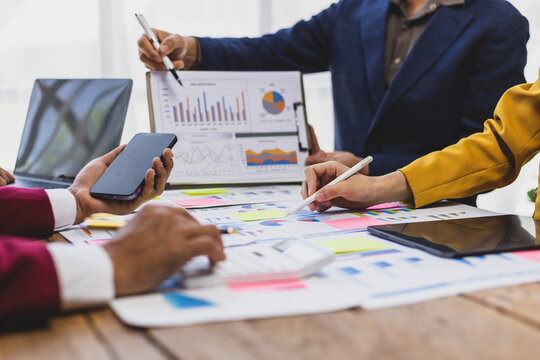 Businessman analyzing marketing and financial chart on desk. Businessman meeting with financial advisor, discussing financial situation analysis and business investment plan.