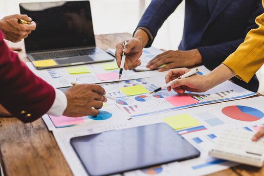 Businessman analyzing financial data with chart and graph. Business team collaborates in office, analyzing data, brainstorming ideas, and developing strategies for success.