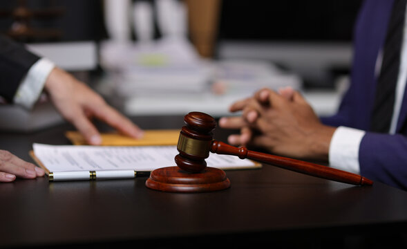 Lawyer reviewing contract agreement with legal documents, Discussing contract agreement at desk with legal document.