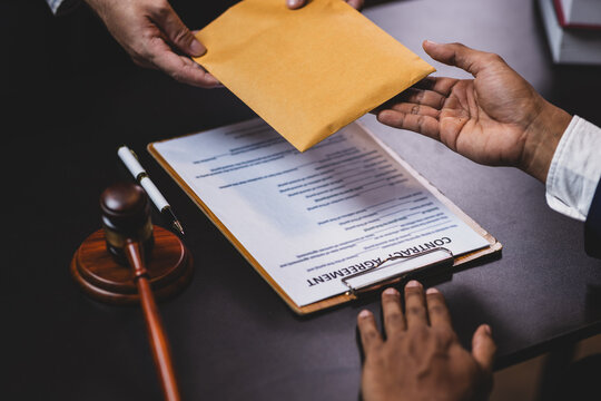 Lawyer receiving envelope with money for bribery. Corrupt lawyer receiving a bribe in an office, showcasing unethical behavior in law and finance. Hands accept money envelope.